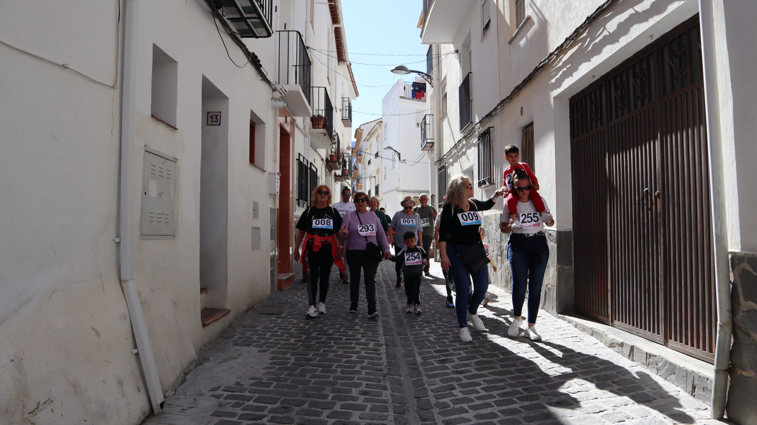 mujeres hombres y niños caminando por la VII marcha de la mujer guejareña